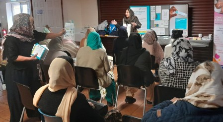 Women in headscarves watching presentation